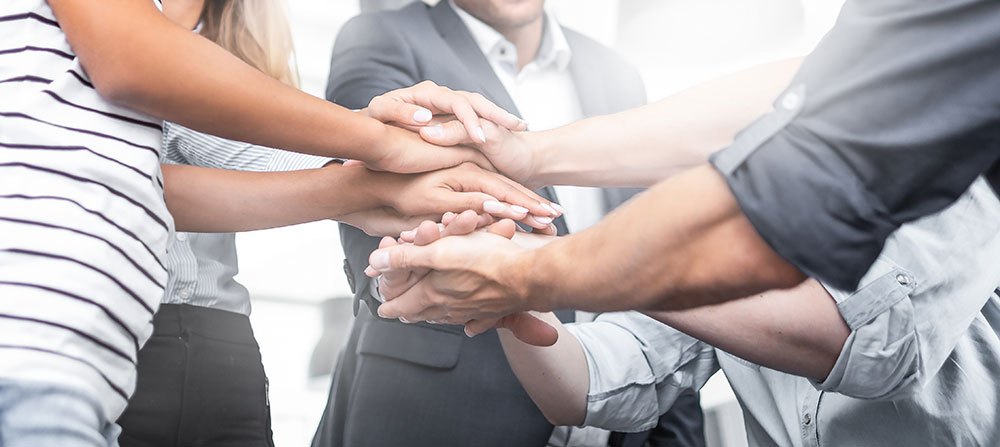 Circle of people stacking their hands together